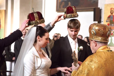 The crowns close up, the priest with the cross before the couple. Ss Cyril and Methodius church, Prague, 2011