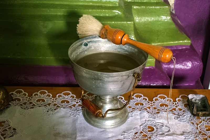 A vessel of blessed water with the sprinkler