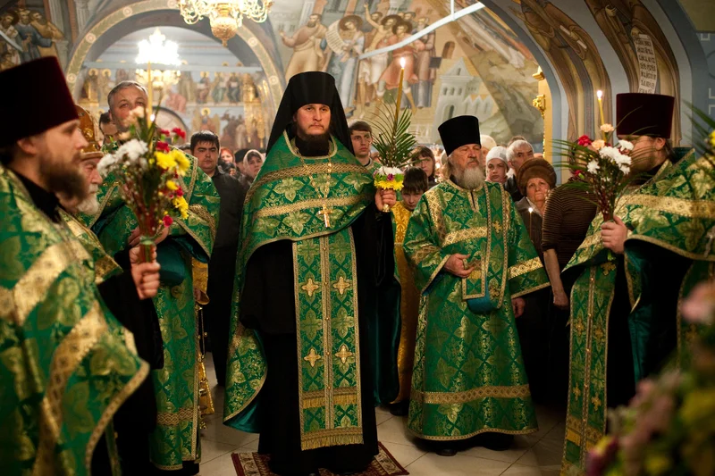 Clergy with willow branches and lit candles at the evening service on the eve of Palm Sunday. Saratov, 2010