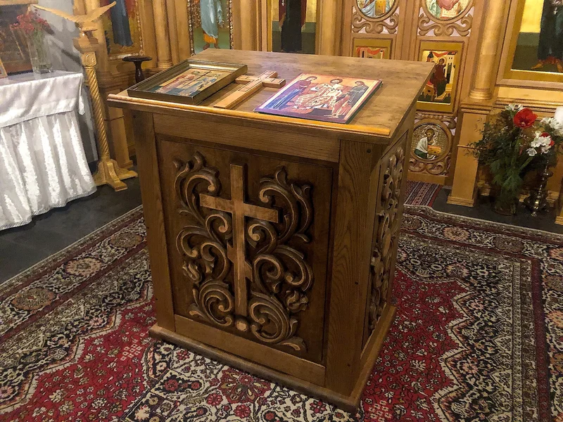 A carved stand with a sloping top holding icons in the middle of the church. Sts Constantine and Helen church, Cologne