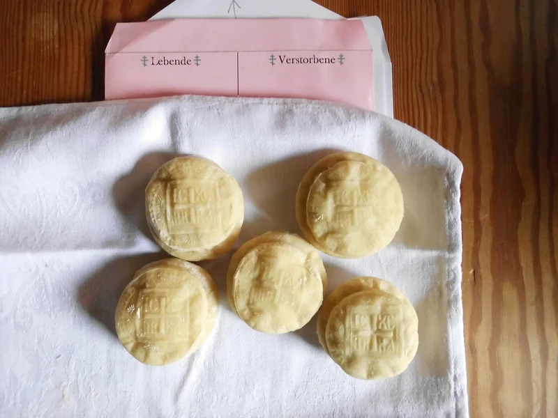 Prosphora loaves stamped IC XC NI KA, with a commemoration slip for the living and the departed