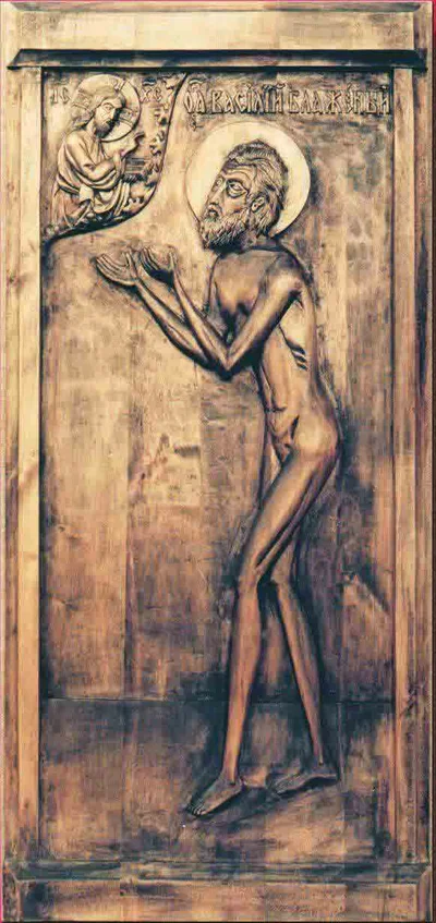 A carved image of Blessed Basil of Moscow, shown naked and praying to Christ