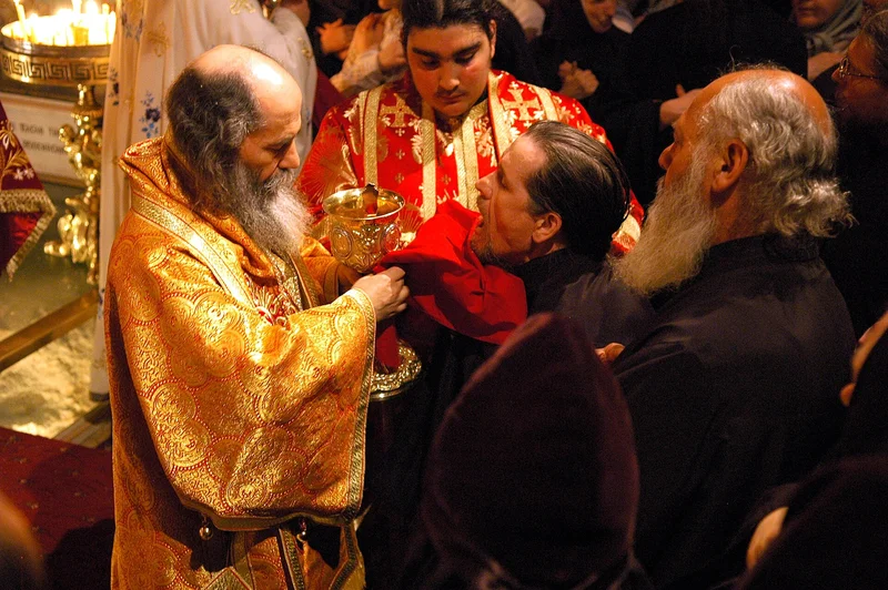 Communion given with the spoon from the chalice, a cloth held under the chin. Jerusalem, 2005