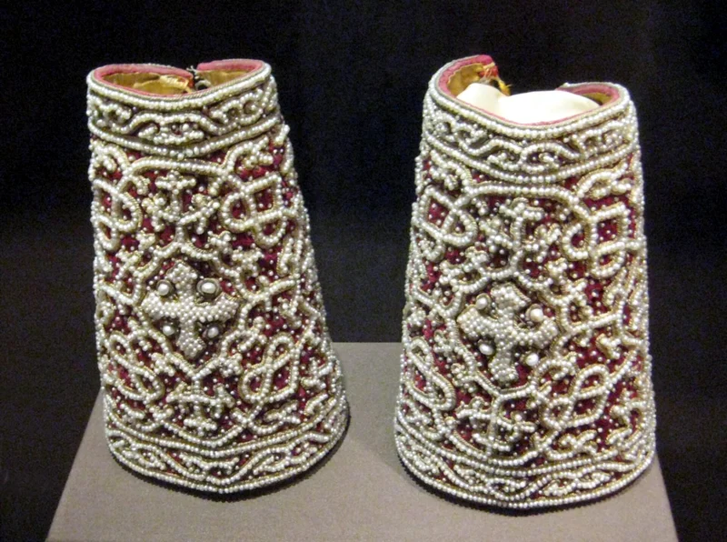 A pair of pearl-embroidered cuffs, each with a cross at the centre