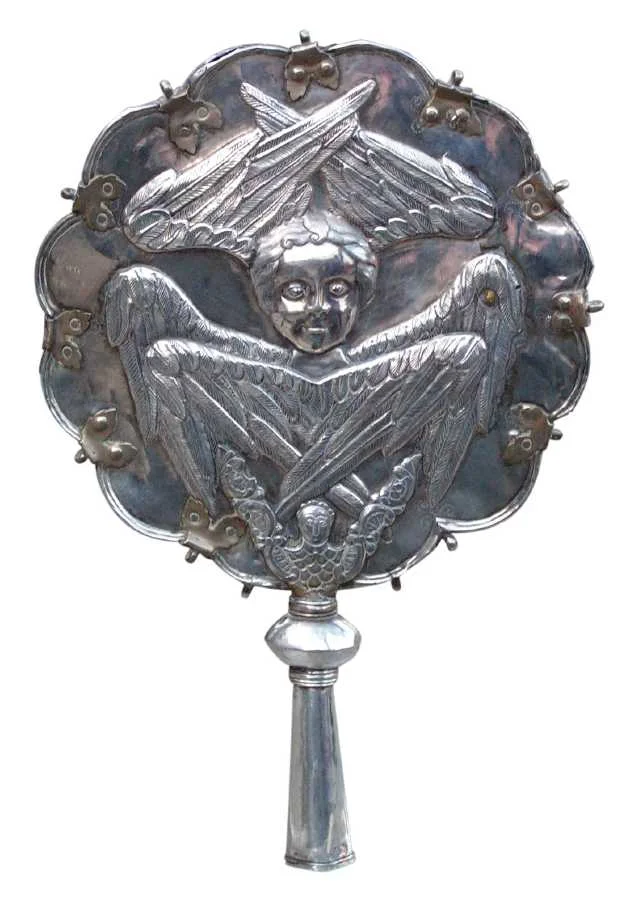 A silver disc with a chased six-winged seraph on a short handle
