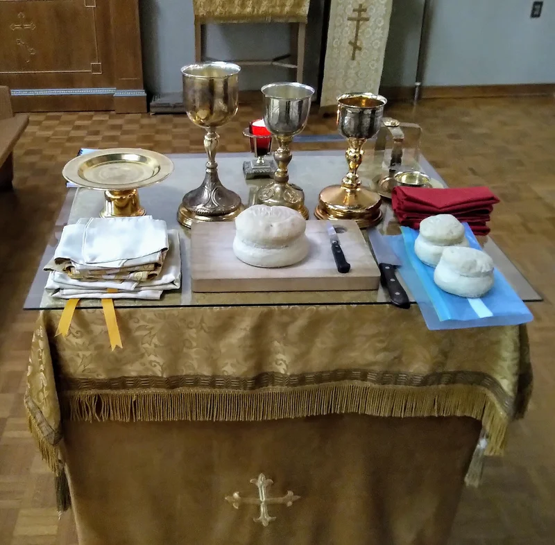 The table set for the proskomedia: chalice, diskos, spear, veils and prosphora loaves