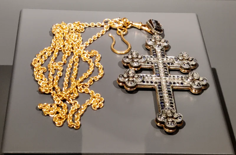 An eight-pointed cross "with ornaments" and the chain it hangs from