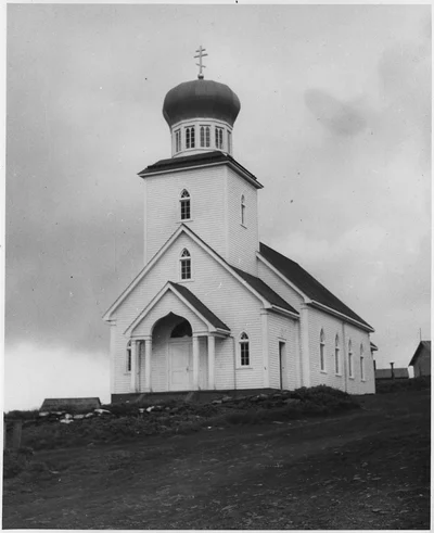 A wooden parish church laid out west to east, with the belfry and cupola over the west entrance. Alaska, early 20th century