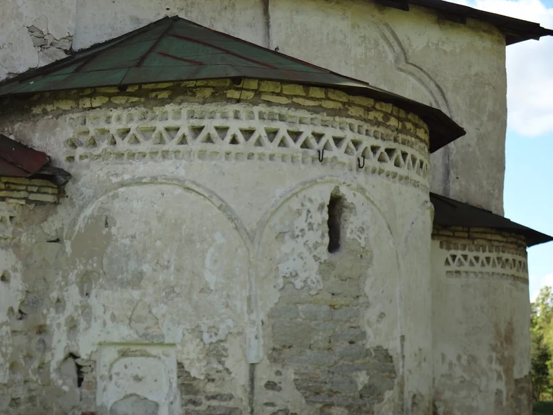 The rounded projections on the east wall of an old church, with a band of ornament along the top