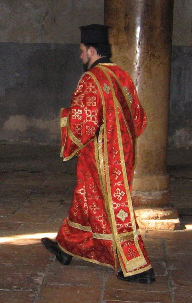 The orarion hangs from the left shoulder down the back over the sticharion. A Greek deacon in the Church of the Nativity, Bethlehem, 2007