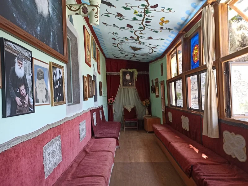 Интерьер келии/приёмной с фотографиями старца Ефрема и его учеников на стенах — не формальная икона, но документальное фото места его подвигов