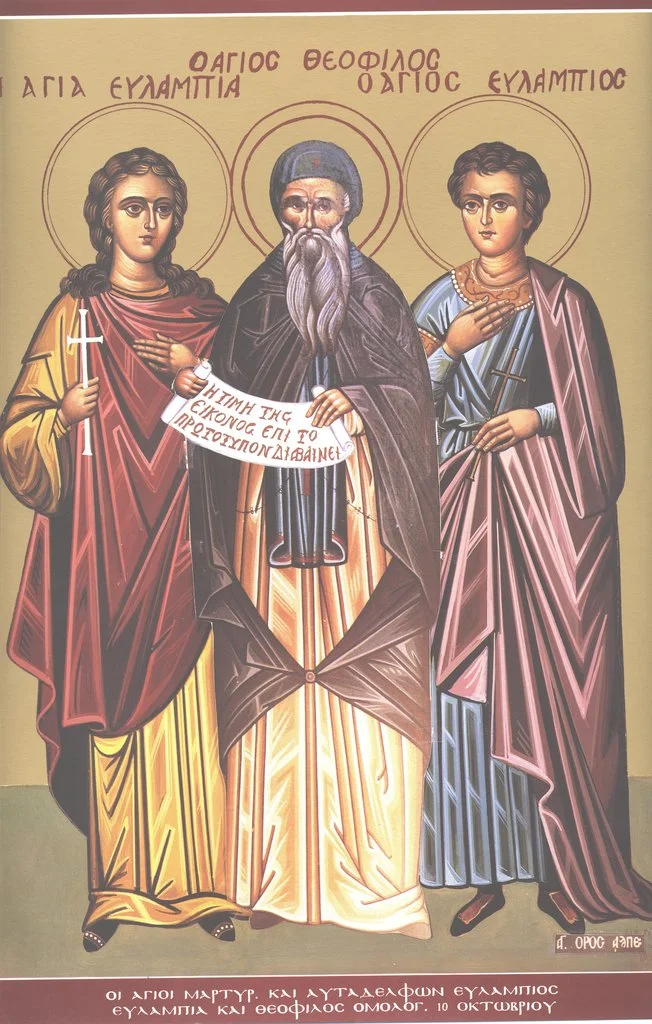 Икона с подписями «Η ΑΓΙΑ ΕΥΛΑΜΠΙΑ», «Ο ΑΓΙΟΣ ΘΕΟΦΙΛΟΣ», «Ο ΑΓΙΟΣ ΕΥΛΑΜΠΙΟΣ» и нижней надписью «Οι Άγιοι Μάρτ. και αυτάδελφοι Ευλάμπιος, Ευλαμπία και Θεόφιλος Ομολ., 10 Οκτωβρίου» (мчч. братья и сестра Евлампий, Евлампия и исп. Феофил, 10 октября)