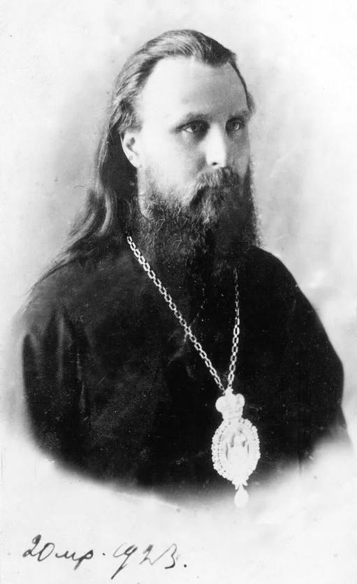 Чёрно-белая фотография молодого монаха с наперсным крестом
